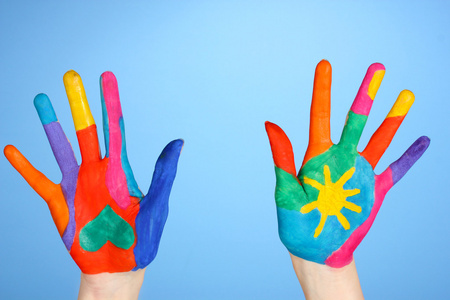 明亮的彩色手上蓝色背景特写照片