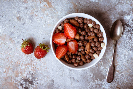 健康早餐与麦片, 浆果和坚果在碗在灰色背景。健康食品概念。平躺