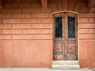 老风化棕色门由木头制成, 橙色墙壁在克罗地亚