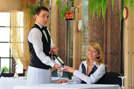 餐厅的服务员提供葡萄酒位访客照片