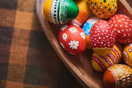 木碗与一堆彩绘彩色复活节彩蛋格子桌布背景
