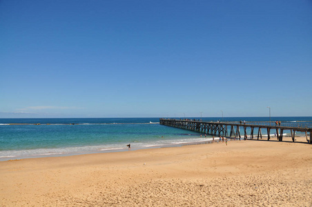 长的木质码头提供步行方式到海。澳大利亚阿德莱德阳光明媚的夏日海景