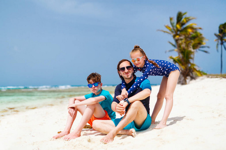 父亲和孩子们在热带岛屿上享受海滩度假