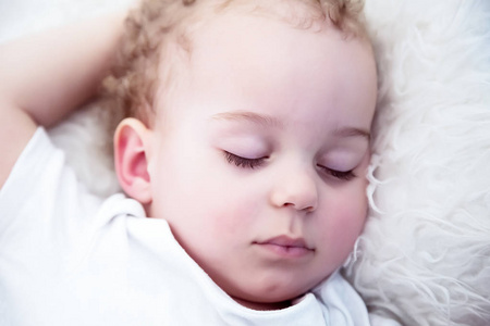 睡觉的小男孩。特写肖像在床上一个美丽的熟睡的男婴。新生儿, 童年主题