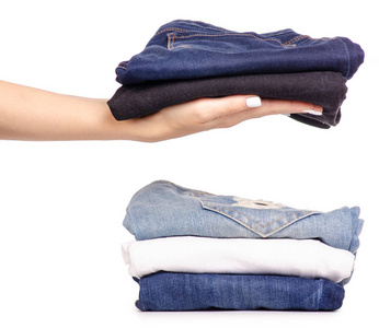 一叠牛仔裤在手照片