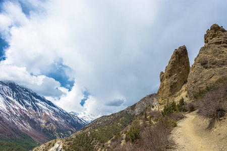 在喜马拉雅山上美丽的小径上的游客。云中的雪山山峰, 尼泊尔