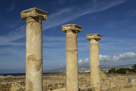 具有离子资本的古柱, 具有云背景的蓝天。萨拉米斯城遗址, 北塞浦路斯