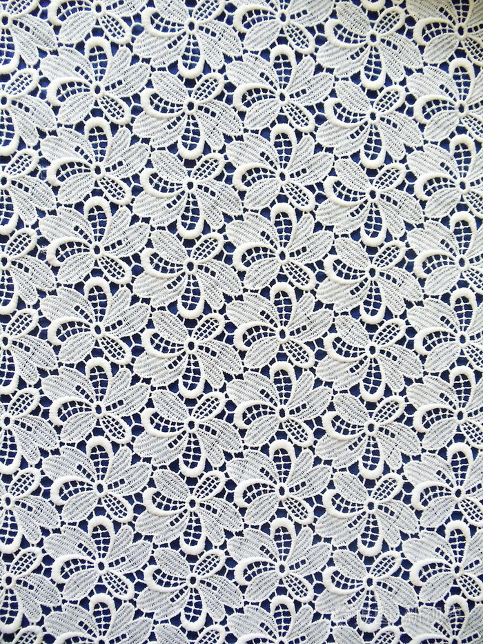 白色蕾丝面料与暗蓝色背景上的花卉图案