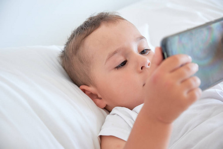 男孩睡觉前和看动画片在智能手机