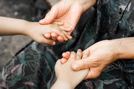 一个抱着老人的小孩子的手, 世界仁慈日概念照片