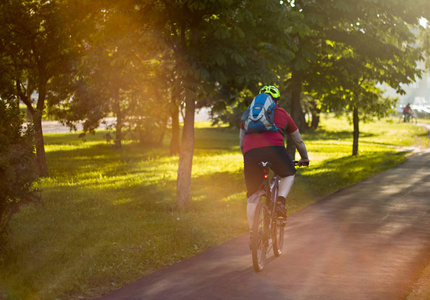 骑自行车的头盔上背着背包在阳光下