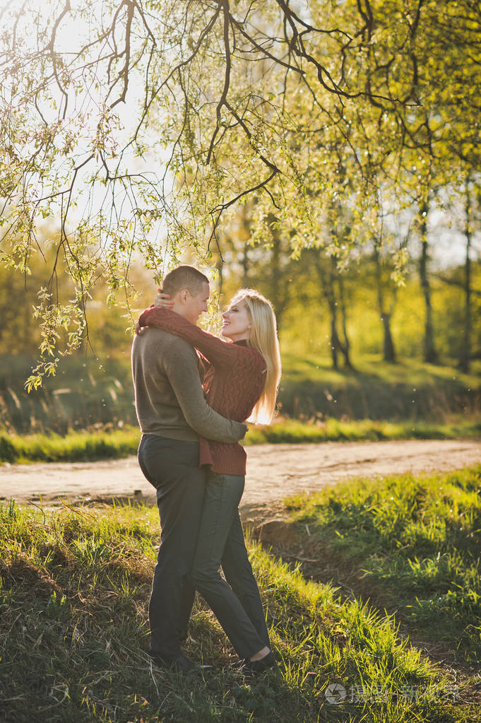 恋人拥抱在树林中的夕阳的光芒