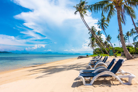 美丽的户外景观与雨伞和椅子上的海滩和海洋与椰子棕榈树度假和旅游