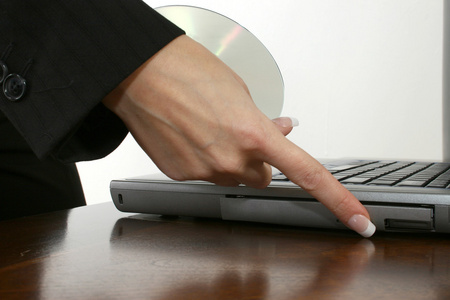 女人的手放在桌子上的手提电脑的 dvd