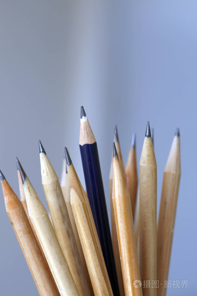 蓝色铅笔聚焦在自然木铅笔横梁上, 在光背景下