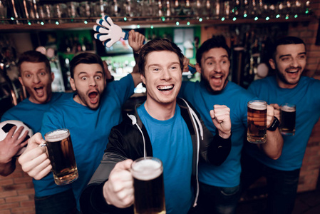 一群足球爱好者观看比赛, 晚上在体育酒吧喝啤酒