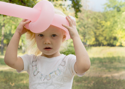 小女孩戴着气球帽子