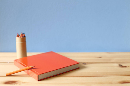 笔记本和彩色铅笔在木桌上