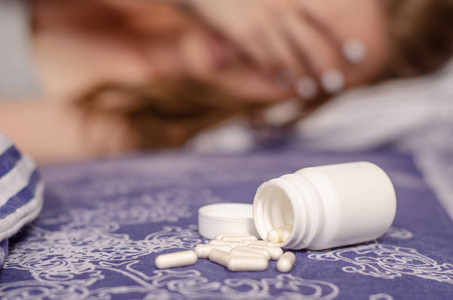 女人躺在床上生病用罐子药片