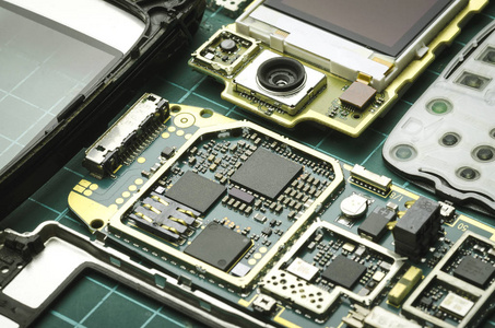 卵磷脂诱导体带半导体元件特写的旧手机拆卸板照片