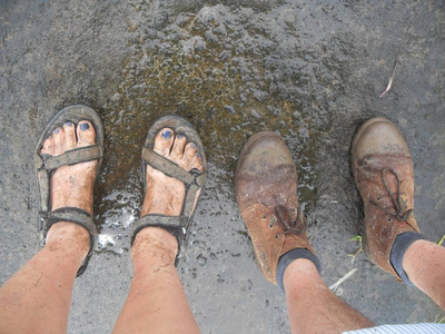 一个人, 一个女人 在热带巴厘岛雨季的雨天远足后, 看着肮脏的脚照片