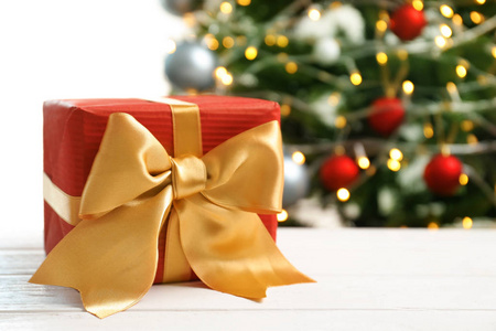 美丽的礼品盒和模糊的圣诞树背景