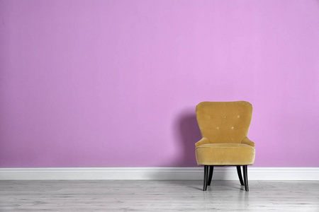 时尚舒适的扶手椅对彩色墙壁。现代室内设计