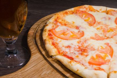 热的一块比萨与融化的奶酪在一个质朴的木桌上