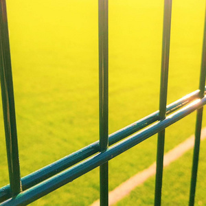 绿栅栏网后面打 minifootball 的草坪场