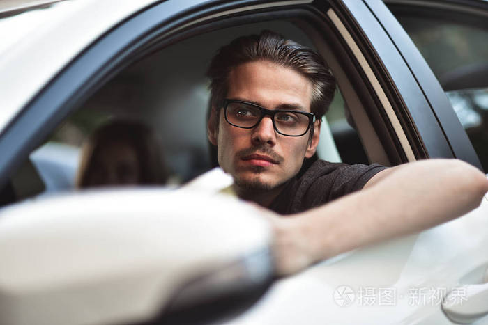 尽情享受吧年轻英俊的家伙坐在车上的形象