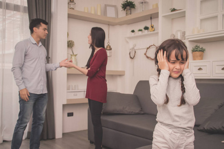 父母家庭争吵的概念, 年轻夫妇的父母在孩子面前打架。孩子们对父母吵架很伤心。孩子们在哭泣和头疼