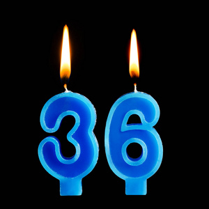 燃烧生日蜡烛的形式36三十六为蛋糕隔离黑色背景