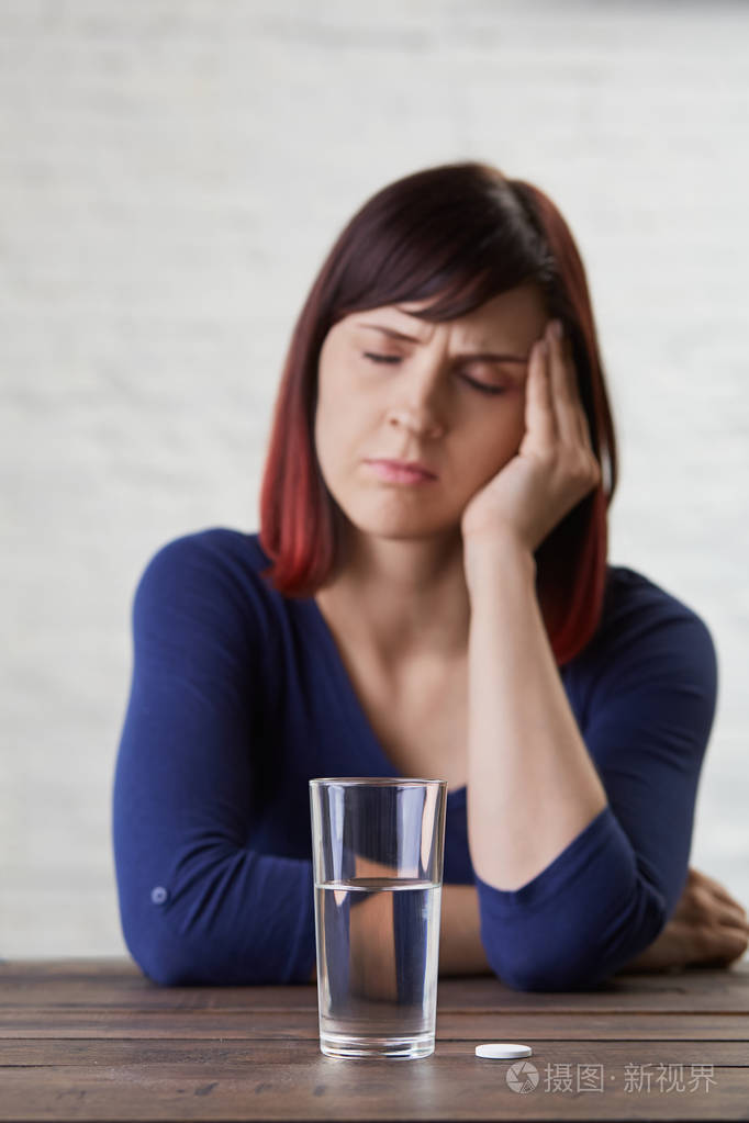 握住手指到她的寺庙和关闭眼睛从痛苦, prepairing 吃药