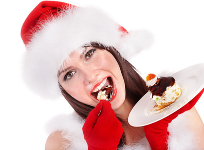 圣诞帽子圣诞女孩在板上吃蛋糕