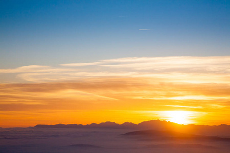 山剪影在日落从意大利阿尔卑斯。背景云