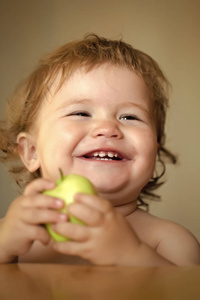 快乐的孩子玩得开心。笑娃娃的肖像与苹果