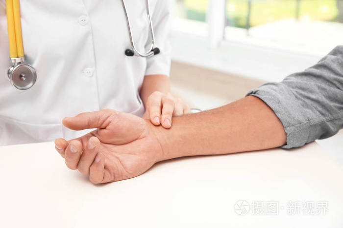医生在医院检查老人脉搏