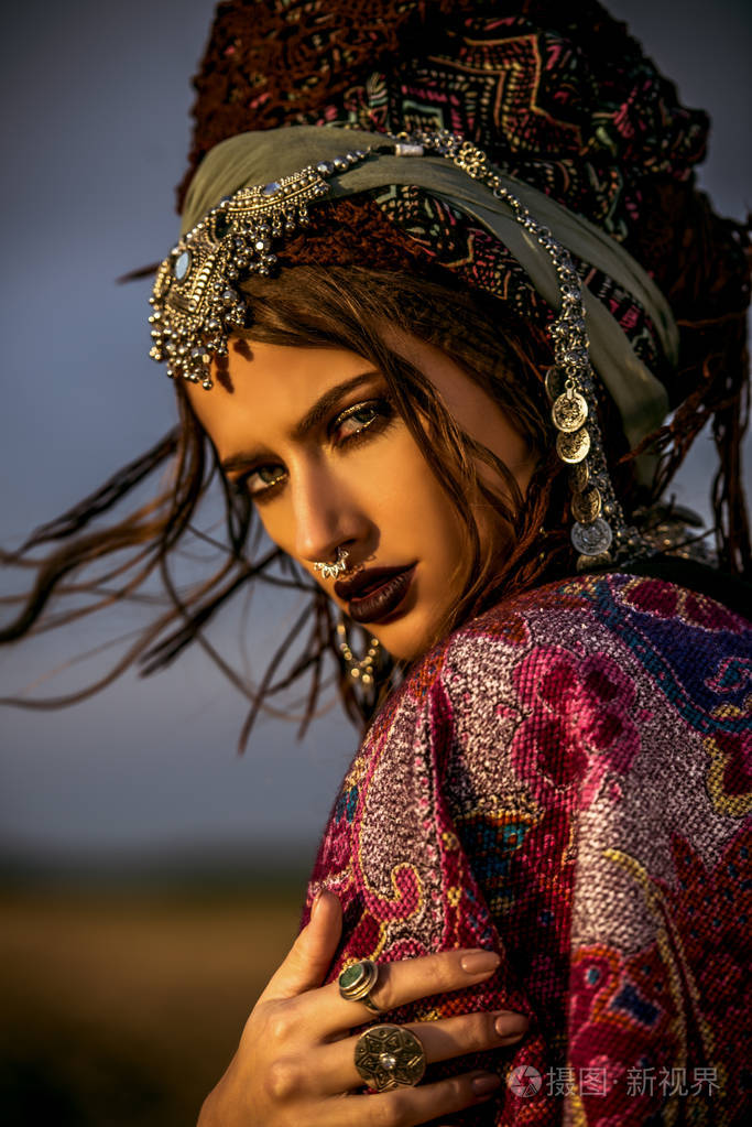 美丽的时装模特在波西米亚风格的衣服,在夕阳的光线.户外时尚