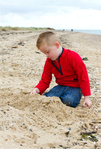 在秋天在海滩上玩的小男孩