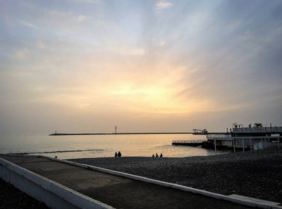 海洋海岸的背景下设置太阳和夕阳