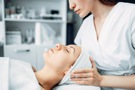 美容师对女性病人美容诊所进行面部按摩。水疗沙龙的面部护肤复壮程序