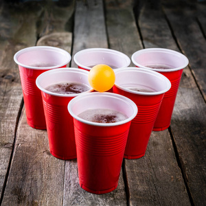大学聚会运动啤酒乒乓球桌设置与塑料杯子, 质朴的木头背景