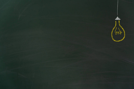 在学校有免费复印空间的黄色灯泡用粉笔涂在肮脏的绿色黑板上