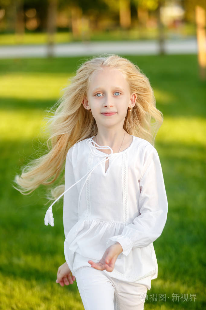 美丽的金发女孩在公园里奔跑