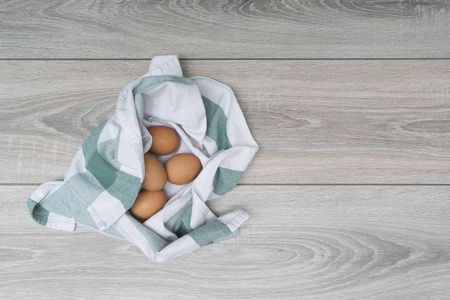 厨房里木桌上的抹布里的一些鸡蛋
