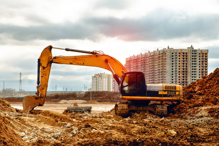 黄色挖掘机在沙地上工作, 在阴天的道路建设