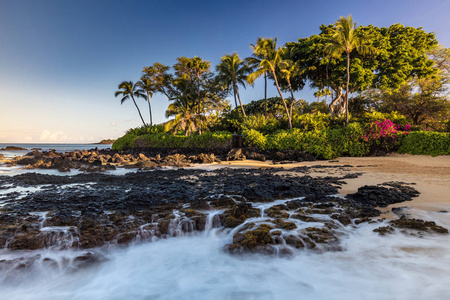 夏威夷茂宜岛南部亚高湾熔岩瀑布。波浪在这个田园般的海滩上的熔岩岩石上坠落