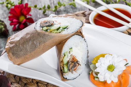 寿司卷有鲑鱼, 奶油芝士, 鳄梨和黄瓜在盘子里。日本料理健康的海洋食品