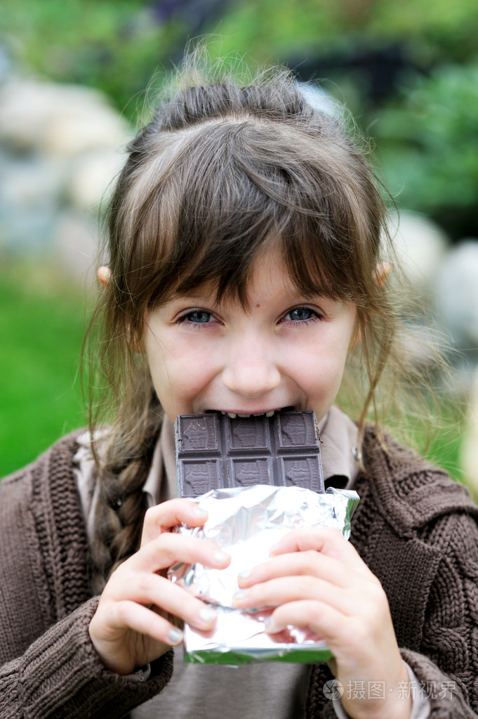 小可爱女孩吃巧克力照片-正版商用图片058ajk-摄图新视界