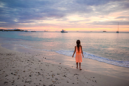 日落时分在海滩上跳舞的小女孩 Sihouette